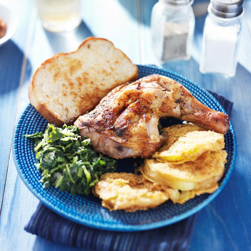 soul food with chicken, fried green tomatoes and collard greens on blue plate