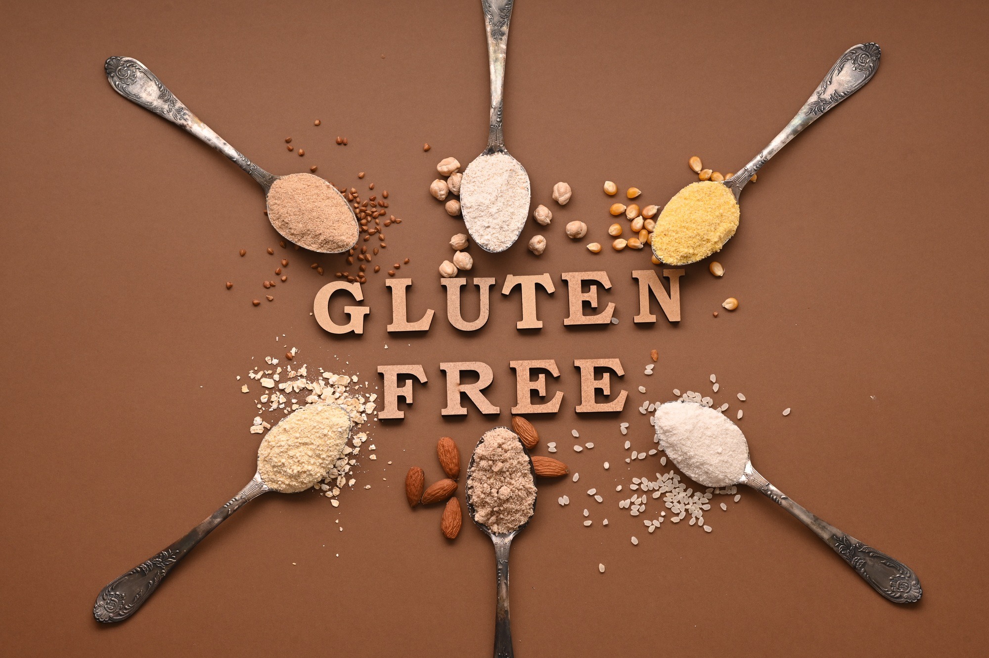 Gluten free text and spoons of various gluten free flour. Flat lay, top.